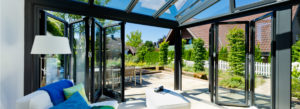 Modern eingerichteter Wintergarten mit geöffneten Falttüren
