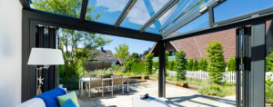 Modern eingerichteter Wintergarten mit geöffneten Falttüren